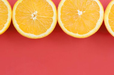 Kırmızı renkte parlak arka plan üzerinde üstten görünüm birkaç turuncu meyve dilimleri. Doymuş narenciye doku görüntü
