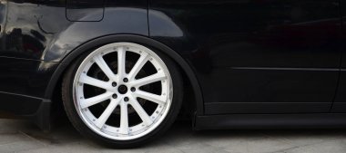 Parlak siyah beyaz tekerlekli arabayla yan görünüm