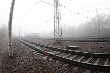 Ukrayna banliyö tren Demiryolu boyunca acele puslu bir sabah. Artan bozulma ile balıkgözü fotoğraf