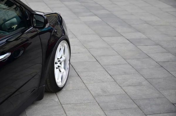 Діагональний Вигляд Чорного Глянцевого Автомобіля Білими Колесами Який Стоїть Квадраті — стокове фото