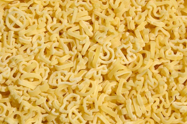 Textura de una gran cantidad de pasta rizada de color amarillo crudo — Foto de Stock