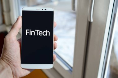 Bir kişi elinde tutuyor bir siyah smartphone ekranda beyaz bir yazıt görür. Fintech