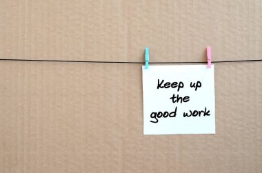 Almak yukarıya iyi iş. Not bir clothespin kahverengi karton bir arka plan üzerinde bir ip üzerinde asılı beyaz bir etiket üzerine yazılmış