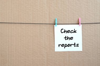 Raporları denetleyin. Not bir clothespin kahverengi karton bir arka plan üzerinde bir ip üzerinde asılı beyaz bir etiket üzerine yazılmış