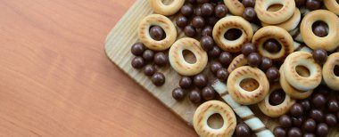 Gevrek tübüllerin, çikolata eritme topları ve simit ahşap yüzeyde yalan. Çeşitli tatlılar karışımı