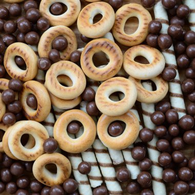 Çıtır çıtır tatlı tübüllerin, çikolata eritme topları ve sarı simit bir sürü yalan bir ahşap yüzeye. Görünümü kapatın