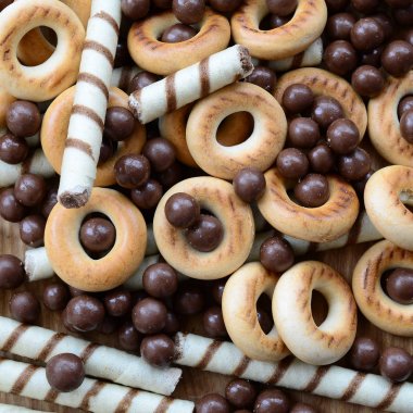 Çıtır çıtır tatlı tübüllerin, çikolata eritme topları ve sarı simit bir sürü yalan bir ahşap yüzeye. Görünümü kapatın