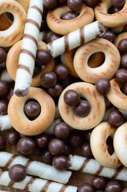 Çıtır çıtır tatlı tübüllerin, çikolata eritme topları ve sarı simit bir sürü yalan bir ahşap yüzeye. Görünümü kapatın