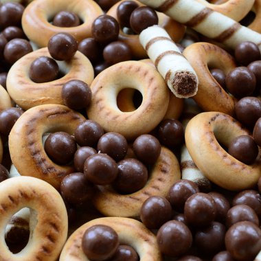 Çıtır çıtır tatlı tübüllerin, çikolata eritme topları ve sarı simit bir sürü yalan bir ahşap yüzeye. Görünümü kapatın