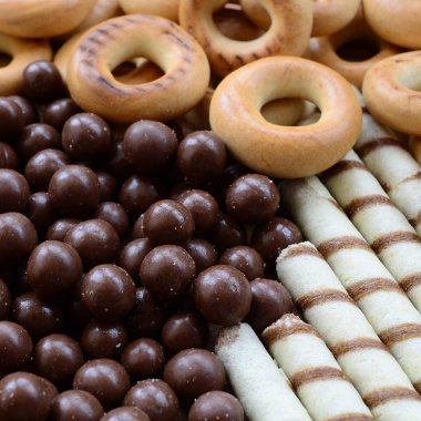 Çıtır çıtır tatlı tübüllerin, çikolata eritme topları ve sarı simit bir sürü yalan bir ahşap yüzeye. Görünümü kapatın