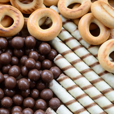 Çıtır çıtır tatlı tübüllerin, çikolata eritme topları ve sarı simit bir sürü yalan bir ahşap yüzeye. Görünümü kapatın
