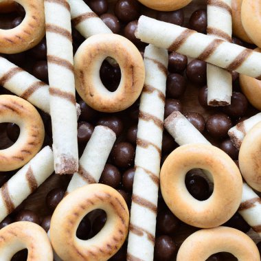 Çıtır çıtır tatlı tübüllerin, çikolata eritme topları ve sarı simit bir sürü yalan bir ahşap yüzeye. Görünümü kapatın