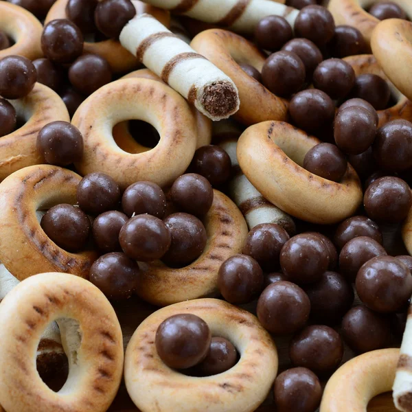 Çıtır çıtır tatlı tübüllerin, çikolata eritme topları ve sarı simit bir sürü yalan bir ahşap yüzeye. Görünümü kapatın