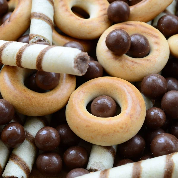 Çıtır çıtır tatlı tübüllerin, çikolata eritme topları ve sarı simit bir sürü yalan bir ahşap yüzeye. Görünümü kapatın