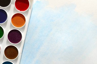 Bir mavi vuruş şeklinde soyut bir suluboya çizim gösteren kağıt üzerine suluboya yeni bir dizi yatıyor. Gençler arasında amatör resim kavramı