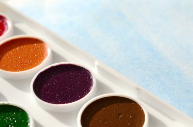 Bir mavi vuruş şeklinde soyut bir suluboya çizim gösteren kağıt üzerine suluboya yeni bir dizi yatıyor. Gençler arasında amatör resim kavramı