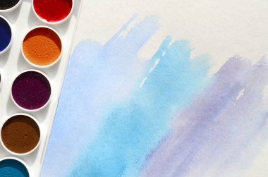 Bir mavi vuruş şeklinde soyut bir suluboya çizim gösteren kağıt üzerine suluboya yeni bir dizi yatıyor. Gençler arasında amatör resim kavramı