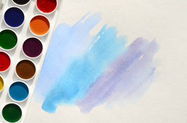 Bir mavi vuruş şeklinde soyut bir suluboya çizim gösteren kağıt üzerine suluboya yeni bir dizi yatıyor. Gençler arasında amatör resim kavramı