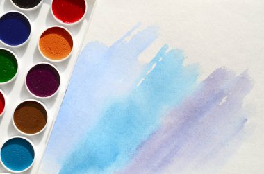 Bir mavi vuruş şeklinde soyut bir suluboya çizim gösteren kağıt üzerine suluboya yeni bir dizi yatıyor. Gençler arasında amatör resim kavramı