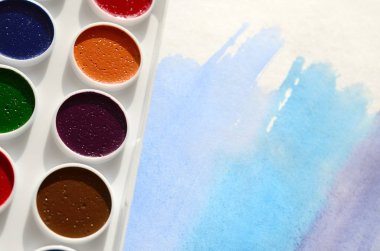 Bir mavi vuruş şeklinde soyut bir suluboya çizim gösteren kağıt üzerine suluboya yeni bir dizi yatıyor. Gençler arasında amatör resim kavramı