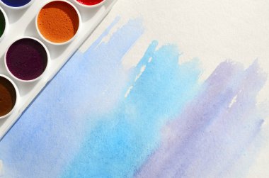 Bir mavi vuruş şeklinde soyut bir suluboya çizim gösteren kağıt üzerine suluboya yeni bir dizi yatıyor. Gençler arasında amatör resim kavramı