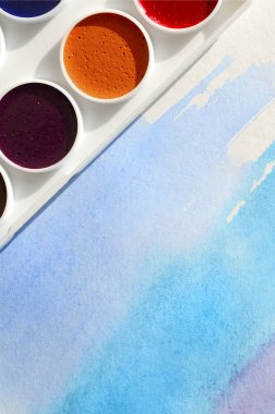 Bir mavi vuruş şeklinde soyut bir suluboya çizim gösteren kağıt üzerine suluboya yeni bir dizi yatıyor. Gençler arasında amatör resim kavramı