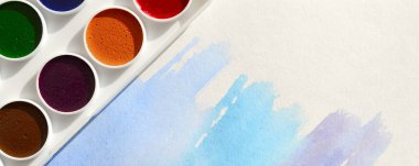 Bir mavi vuruş şeklinde soyut bir suluboya çizim gösteren kağıt üzerine suluboya yeni bir dizi yatıyor. Gençler arasında amatör resim kavramı