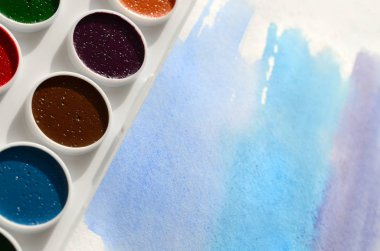 Bir mavi vuruş şeklinde soyut bir suluboya çizim gösteren kağıt üzerine suluboya yeni bir dizi yatıyor. Gençler arasında amatör resim kavramı