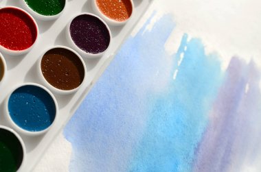 Bir mavi vuruş şeklinde soyut bir suluboya çizim gösteren kağıt üzerine suluboya yeni bir dizi yatıyor. Gençler arasında amatör resim kavramı