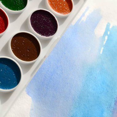 Bir mavi vuruş şeklinde soyut bir suluboya çizim gösteren kağıt üzerine suluboya yeni bir dizi yatıyor. Gençler arasında amatör resim kavramı