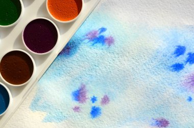 Bir mavi vuruş şeklinde soyut bir suluboya çizim gösteren kağıt üzerine suluboya yeni bir dizi yatıyor. Gençler arasında amatör resim kavramı