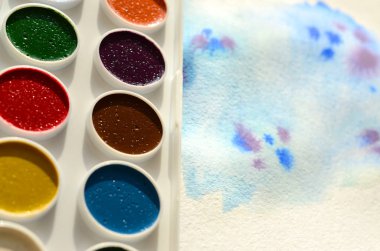 Bir mavi vuruş şeklinde soyut bir suluboya çizim gösteren kağıt üzerine suluboya yeni bir dizi yatıyor. Gençler arasında amatör resim kavramı