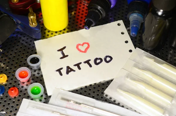 タトゥーが大好きです テキストは 入れ墨の様々 な機器の間で紙の小さなシートに書かれています — ストック写真