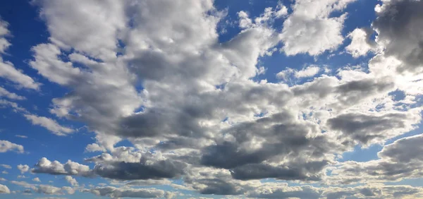 多くの小さな雲が太陽をブロックと青い曇り空 — ストック写真