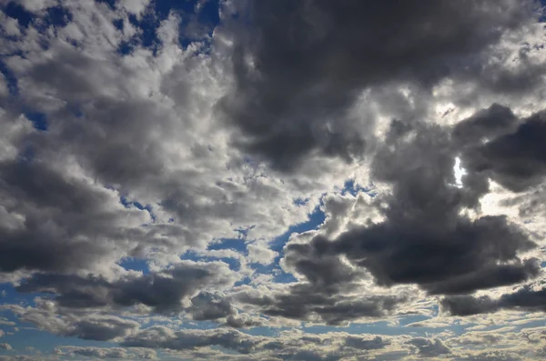 多くの小さな雲が太陽をブロックと青い曇り空 — ストック写真