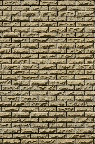 Texture of brick wall from relief stones under bright sunlight