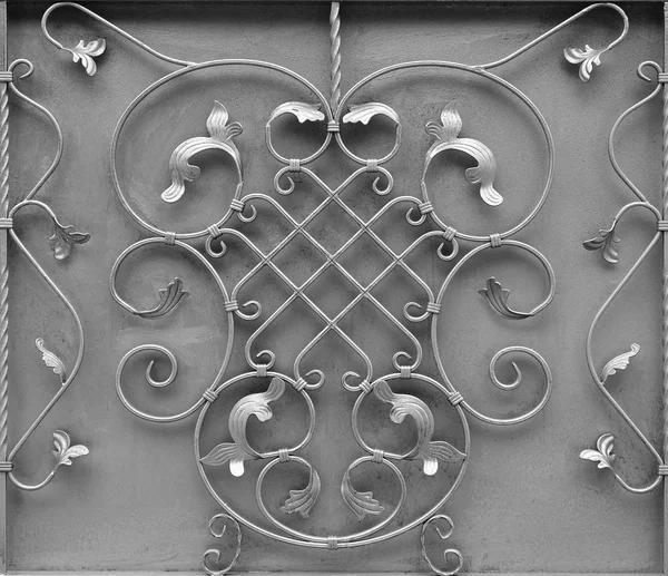 The texture of the silver metal gate with a beautiful floral pattern of forged metal