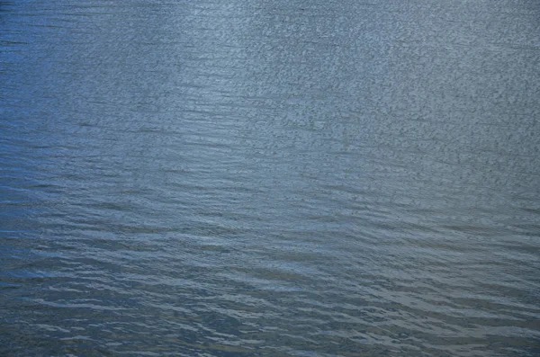 The texture of dark river water under the influence of wind, imprinted in perspective. Horizontal image