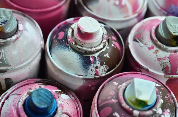 A lot of used spray cans of paint close-up. Dirty and smeared cans for drawing graffiti. The concept of a sweeping and careless drawing of paint. Creative art image