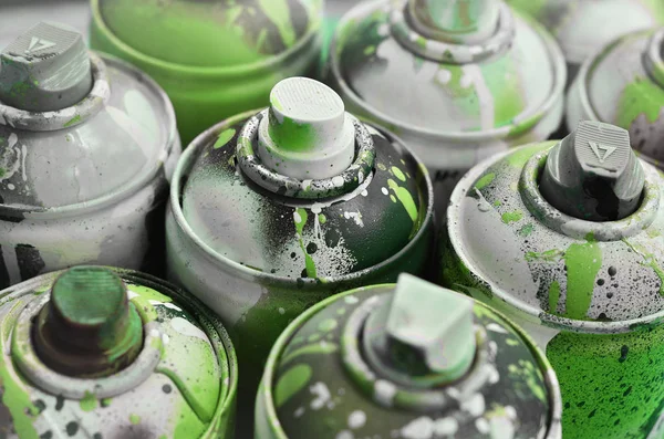 A lot of used spray cans of paint close-up. Dirty and smeared cans for drawing graffiti. The concept of a sweeping and careless drawing of paint. Creative art image