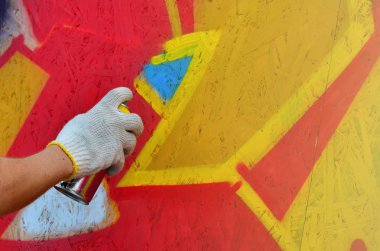 Bir el bir sprey ile yeni bir grafiti duvara çekiyor olabilir. Bir ahşap duvar yakın çekim bir grafiti çizim işlemi fotoğrafı. Sokak sanatı ve yasadışı vandalizm kavramı