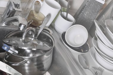 Yıkanmamış yemekleri mutfak lavabo ve tezgah üzerinde büyük bir yığın. Bir sürü aletleri ve mutfak aletleri yıkama önce. Günlük rutin ve karmaşıklık pişirme kavramı