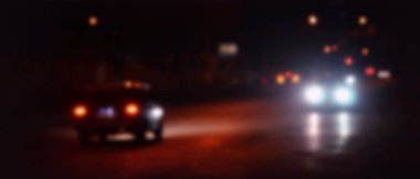 Gece ışıkları büyük şehir, bokeh trafik ışıkları ve yaklaşan araba farlar ile bulanık gece avenue