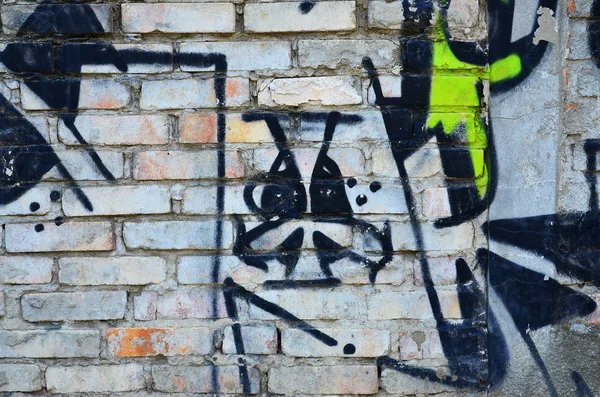 Texture of a fragment of the wall with graffiti painting, which is depicted on it. An image of a piece of graffiti drawing as a photo on street art and graffiti culture topics