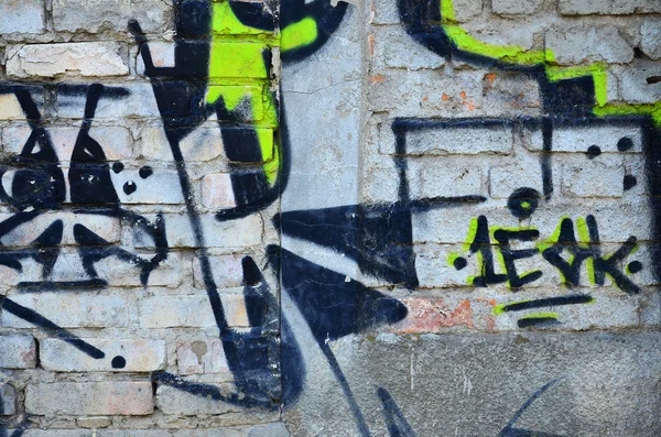 Texture of a fragment of the wall with graffiti painting, which is depicted on it. An image of a piece of graffiti drawing as a photo on street art and graffiti culture topics