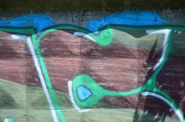 Texture of a fragment of the wall with graffiti painting, which is depicted on it. An image of a piece of graffiti drawing as a photo on street art and graffiti culture topics