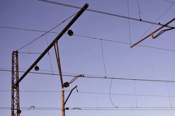 Railroad overhead lines against clear blue sky, Contact wire. High voltage railroad power lines on neutral blue sky background
