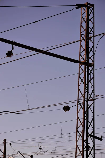 Railroad overhead lines against clear blue sky, Contact wire. High voltage railroad power lines on neutral blue sky background