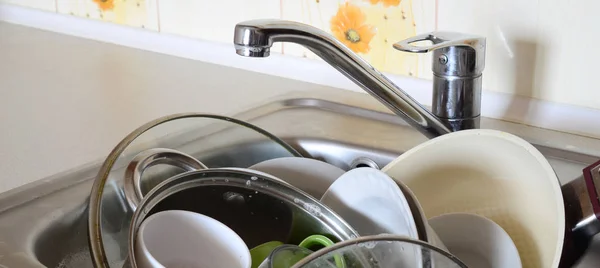 Dirty dishes and unwashed kitchen appliances filled the kitchen sink