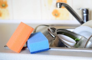 Lavabo bulaşık ile arka plan üzerine bir kaç sünger yalan